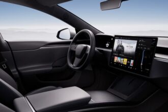 A Tesla car seen from the inside, showing its steering wheel and screen