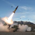 A Russian military vehicle carrying several missiles while one of them is being launched