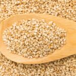 Small but powerful: the hidden secret of sesame seeds A spoon filled with sesame seeds overflowing from it.
