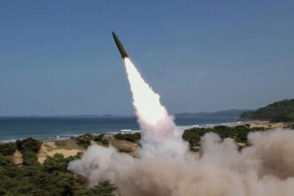 A North Korean tank vehicle launching a missile from the ground toward the sea