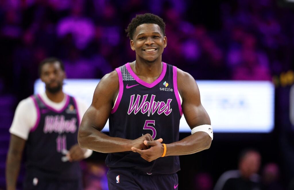 Anthony Edwards holding his hands together while smiling after taking the lead in a game.