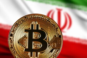 A Bitcoin coin in front of the Iran flag with its green, white, and red colors.