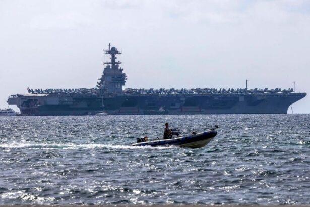 An aircraft carrier on the horizon, awaiting orders at sea.