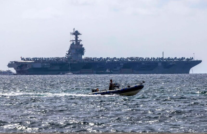 An aircraft carrier on the horizon, awaiting orders at sea.