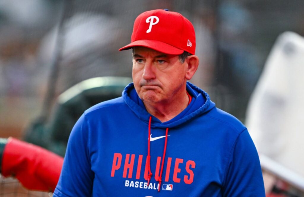 The experienced baseball manager wearing a blue jacket and a red Philadelphia Phillies cap.
