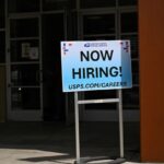 A blue sign that says a company is hiring