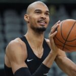 Victor about to take a shot during a training session with a shaved head.