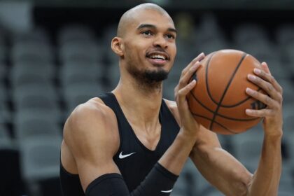 Victor about to take a shot during a training session with a shaved head.