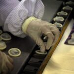 A person placing condoms in each fitting room.