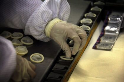 A person placing condoms in each fitting room.