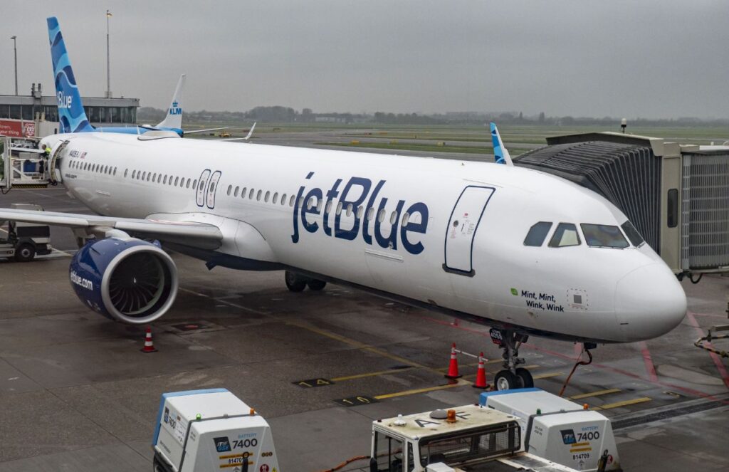 A JetBlue airplane parked waiting for all its passengers at an airport