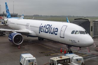 A JetBlue airplane parked waiting for all its passengers at an airport