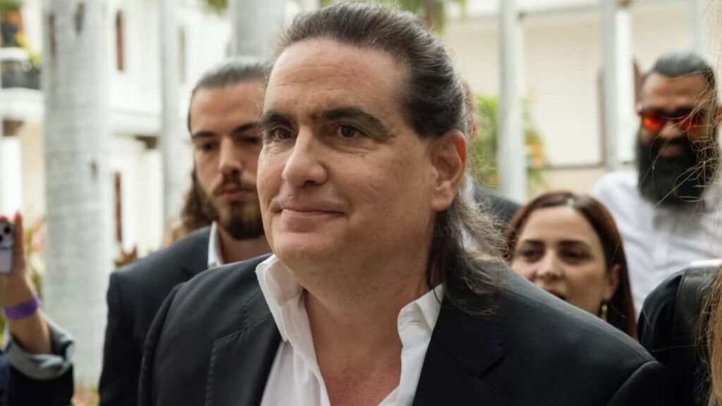 The Venezuelan businessman being escorted by several people while entering a building.
