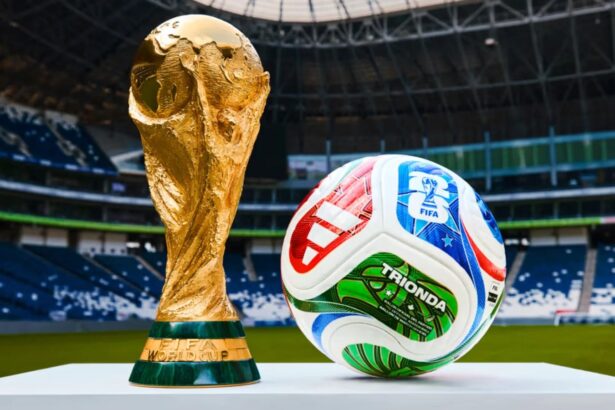 A FIFA World Cup trophy next to the ball that will be used throughout the entire tournament.