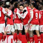 The Arsenal FC players celebrating a goal euphorically.