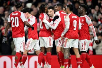 The Arsenal FC players celebrating a goal euphorically.