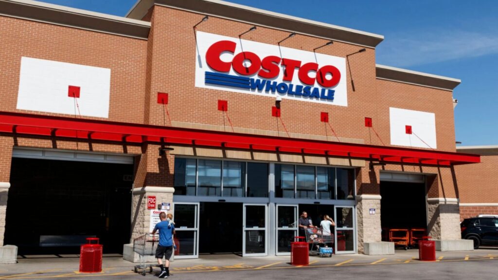 A panoramic view of the front of a Costco store with several people entering and leaving.