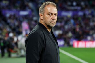 The German coach from the sidelines directing his 11 players on the field.