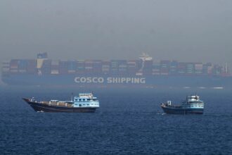 Two small Iranian boats stopping the advance of a massive ship trying to pass through the Strait of Hormuz.