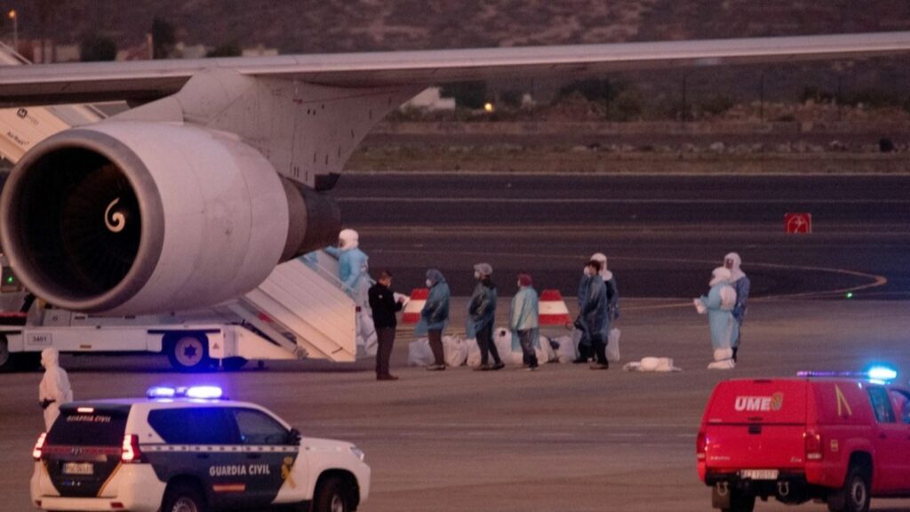 Several people wearing biohazard suits trying to board a plane linked to hantavirus.