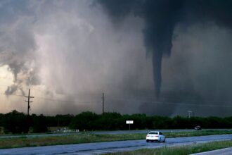 A storm turning into a small hurricane crossing a large field.