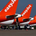 Several easyJet airplanes parked with their white and red colors.