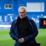 José Mourinho walking along the sideline of the pitch while his team heads toward the locker room.