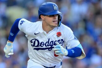 Kiké Hernández wearing his white Los Angeles Dodgers uniform running toward one of the bases.