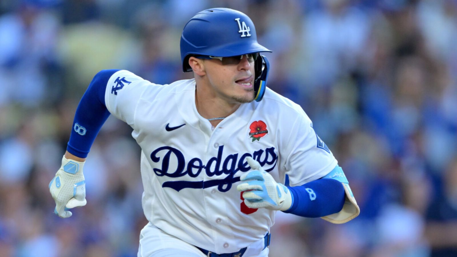 Kiké Hernández wearing his white Los Angeles Dodgers uniform running toward one of the bases.