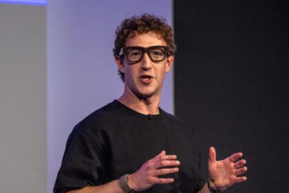 Mark Zuckerberg wearing new affordable smart glasses during a conference with a large audience.