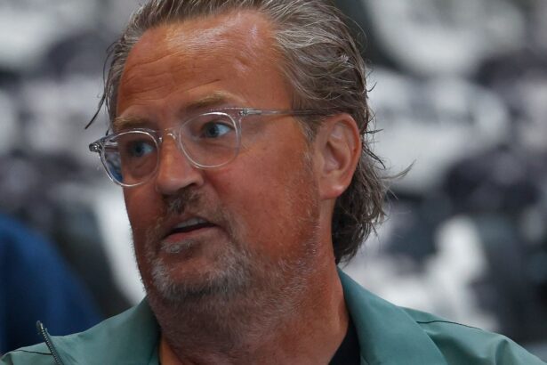The Matthew Perry actor from Friends posing for the cameras with long hair and eye-catching glasses.