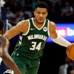The Greek beast of the NBA, Giannis Antetokounmpo, holding the ball while facing another great opposing player.