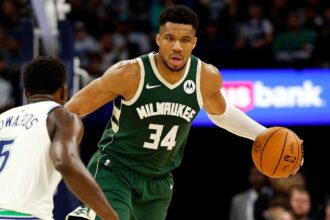 The Greek beast of the NBA, Giannis Antetokounmpo, holding the ball while facing another great opposing player.