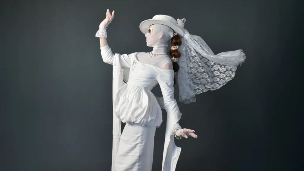 A woman wearing an eccentric white dress posing for the cameras.