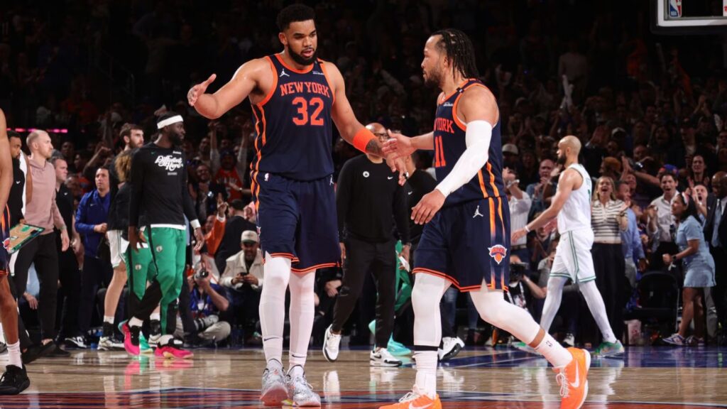 Jalen Brunson and Karl-Anthony Towns high-fiving each other after securing a victory for their team.