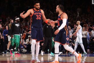 Jalen Brunson and Karl-Anthony Towns high-fiving each other after securing a victory for their team.