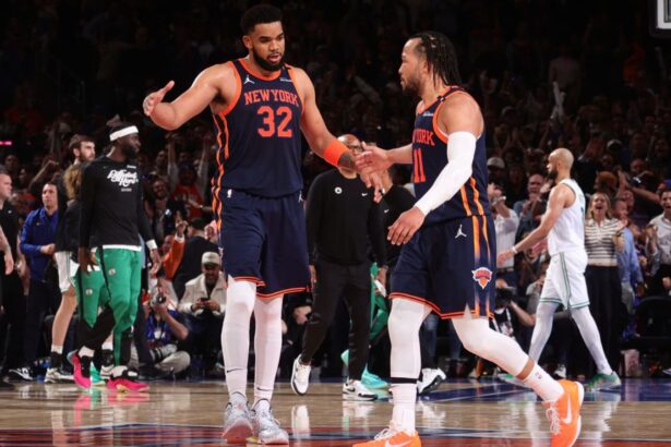 Jalen Brunson and Karl-Anthony Towns high-fiving each other after securing a victory for their team.