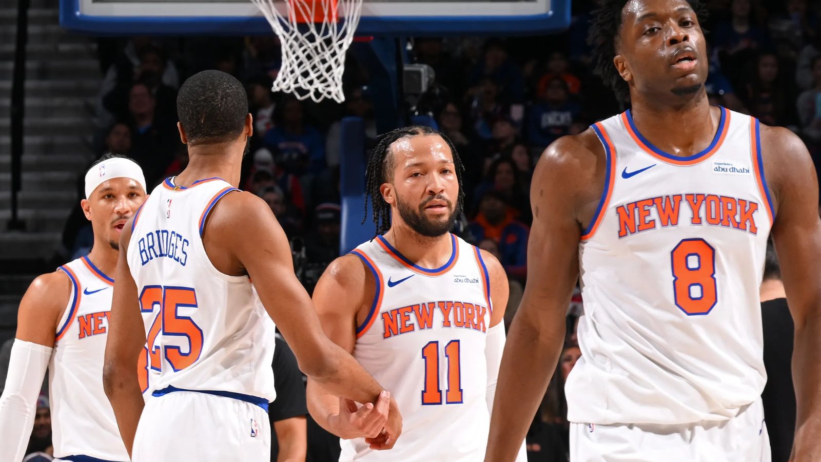 Jalen Brunson and several of his New York Knicks teammates high-fiving each other after defeating their opponent.