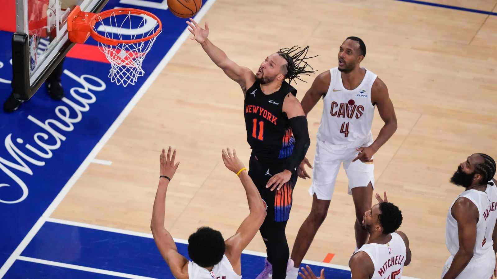 Jalen Brunson scoring from the paint while being surrounded by all the Cleveland Cavaliers players.