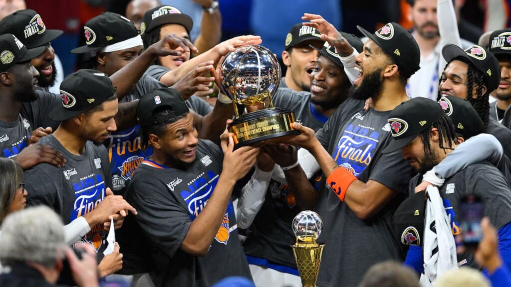 All the players of the New York team celebrating their victory with the trophy in the middle.