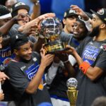 All the players of the New York team celebrating their victory with the trophy in the middle.