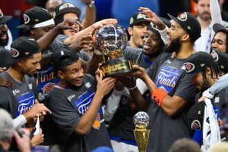 All the players of the New York team celebrating their victory with the trophy in the middle.