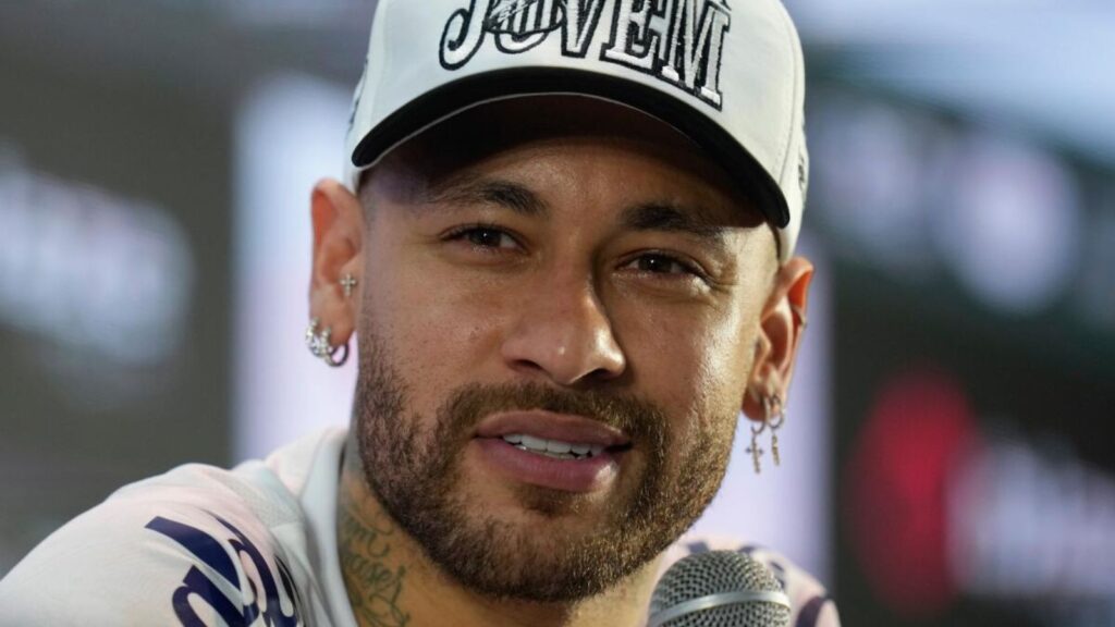 Neymar giving a press conference in front of many news outlets.