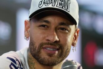 Neymar giving a press conference in front of many news outlets.