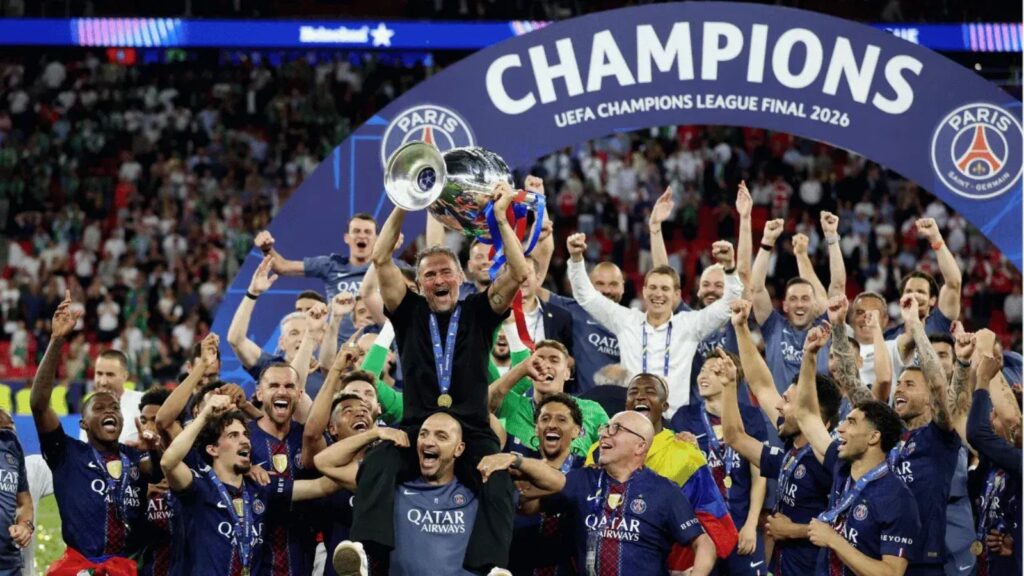 The players carrying their coach on their shoulders while he holds the Champions League trophy.