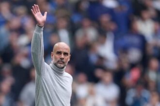The experienced Spanish manager waving goodbye with one hand to the fans and supporters in the stands.