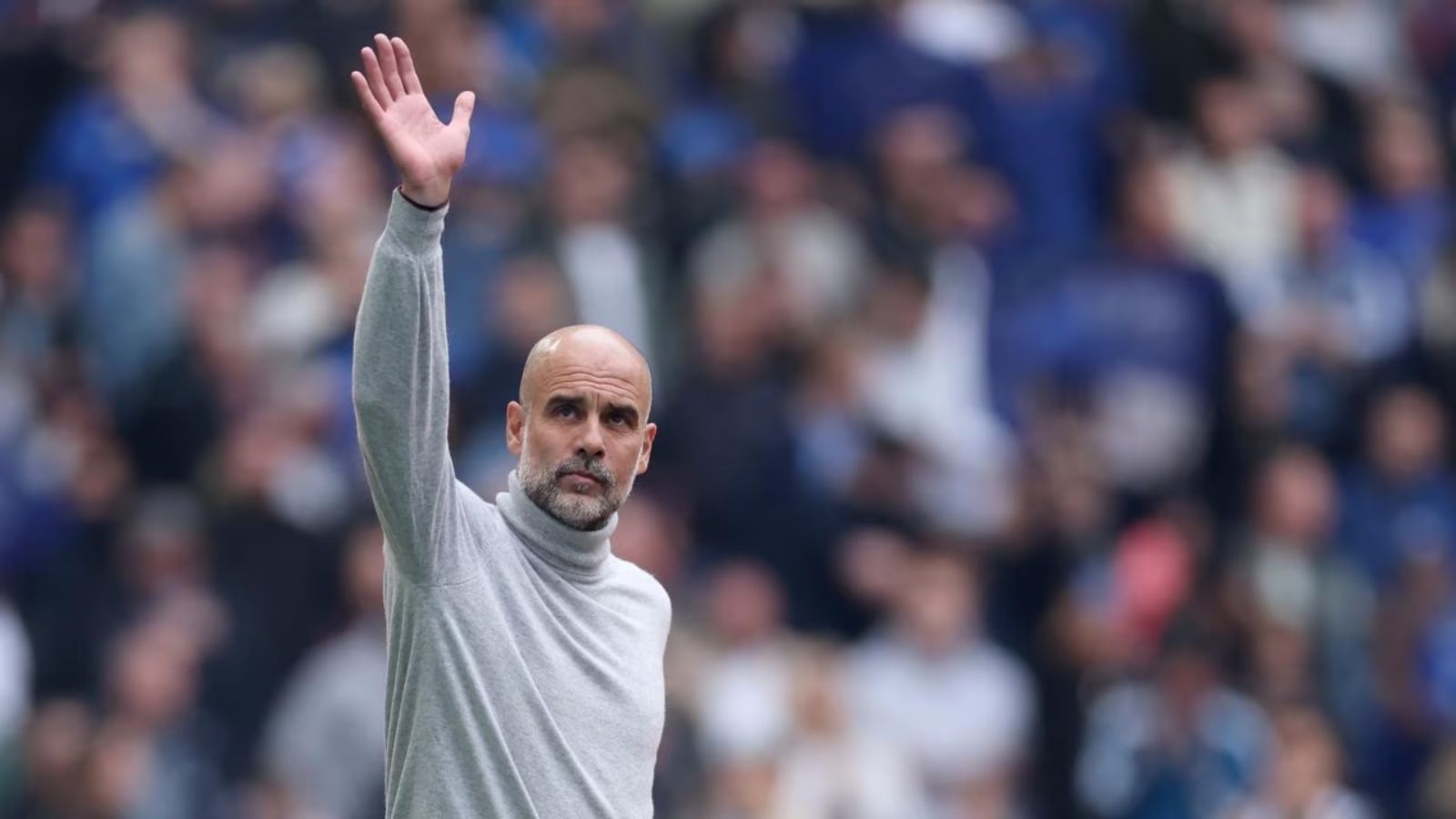 The experienced Spanish manager waving goodbye with one hand to the fans and supporters in the stands.