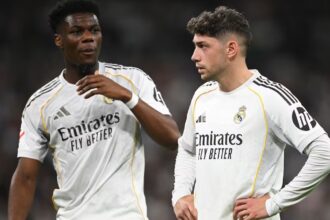 Both players with unfriendly expressions in the middle of a football match.