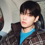 The South Korean artist sitting inside a car for a photoshoot.