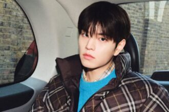 The South Korean artist sitting inside a car for a photoshoot.